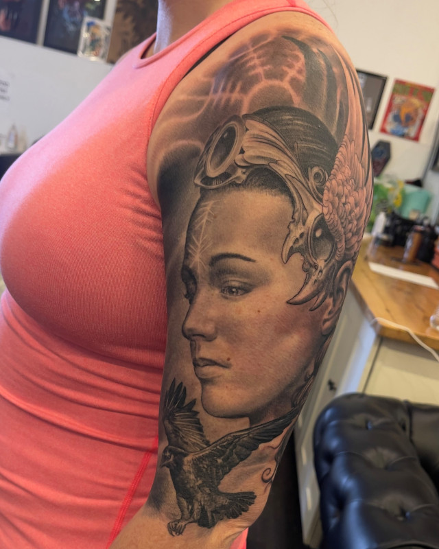 Norse goddess upper arm tattoo with raven done in black and grey ink by Shaine Smith of Sacred Mandala Studio.
