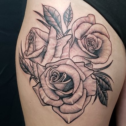 Upper thigh tattoo in black and grey fine lines of three roses.