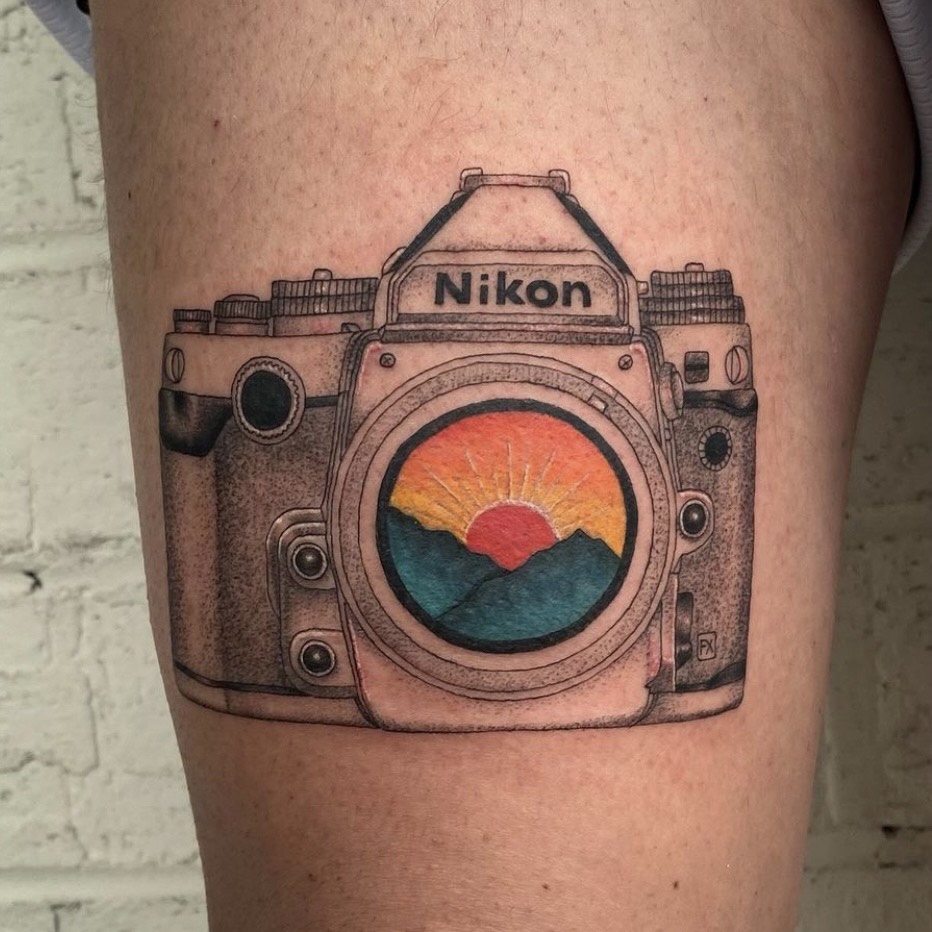 Sacred Mandala Studio tattoo artist - Sarah Cherney - black and grey fine line camera with color sunset over the mountains tattoo.