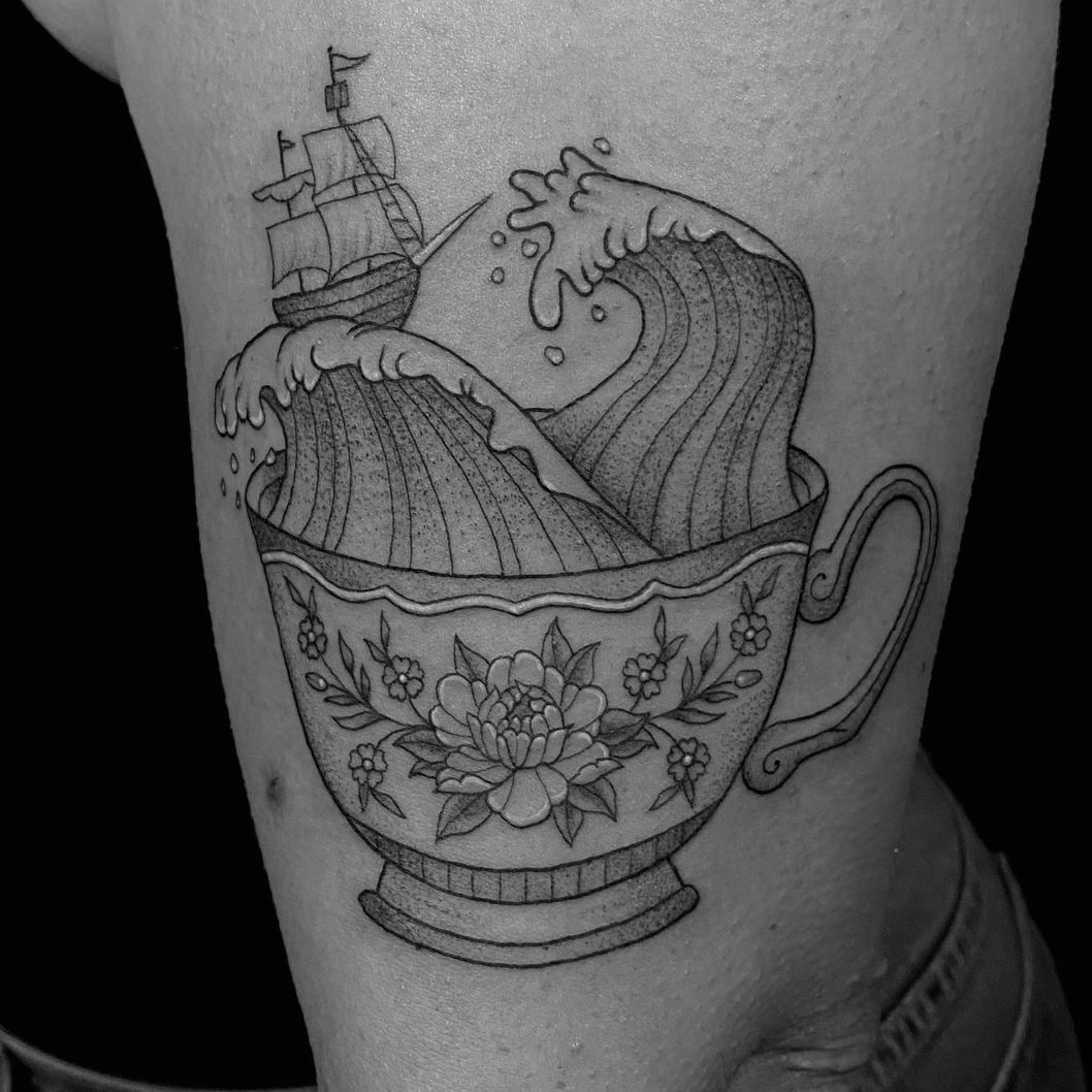 Black, grey and white fine line detailed tattoo of a ship sailing on giant waves within a floral teacup tattooed by Sarah Cherney of Sacred Mandala Studio.